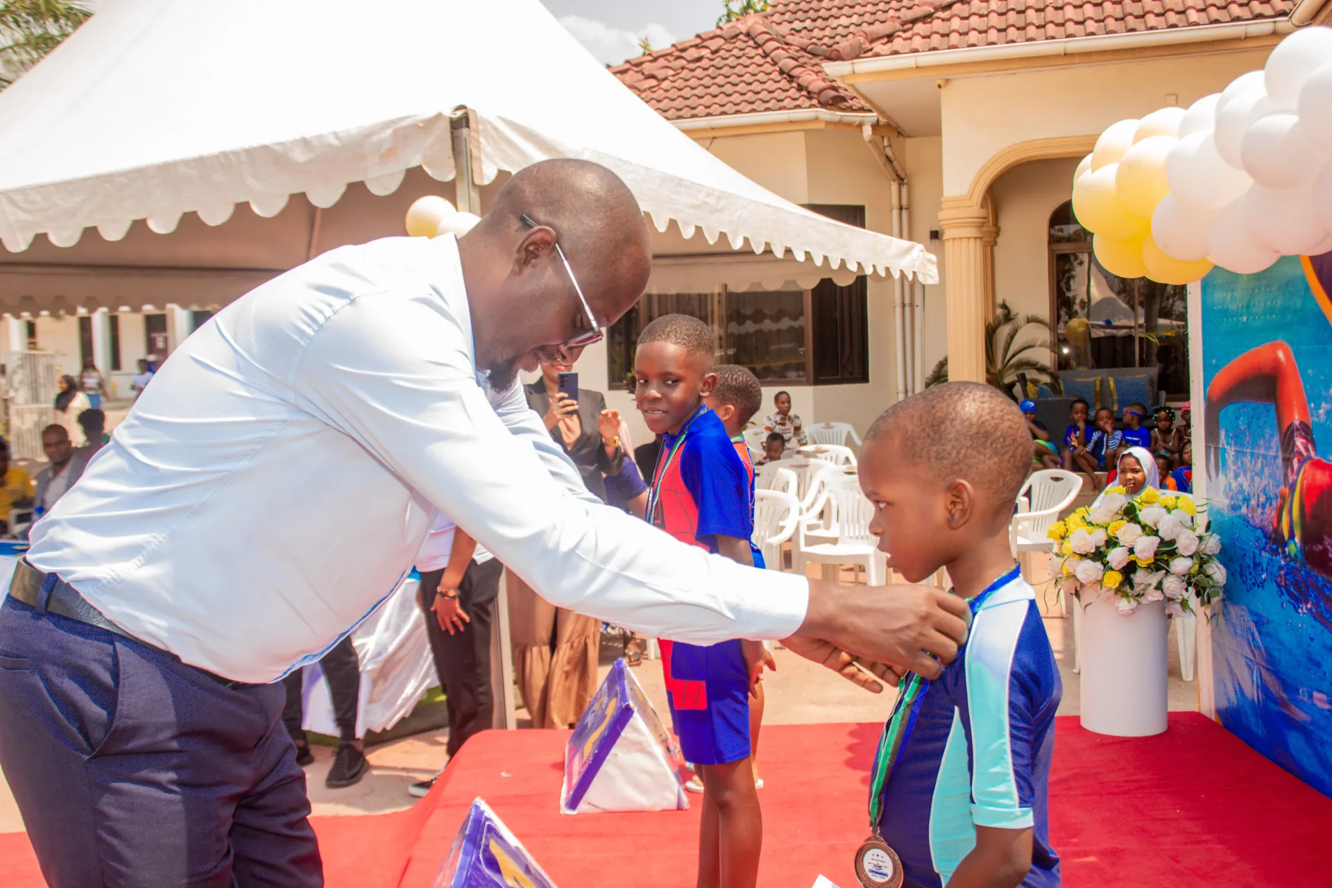 A young swimmer receiving a medal at Milestones Academy