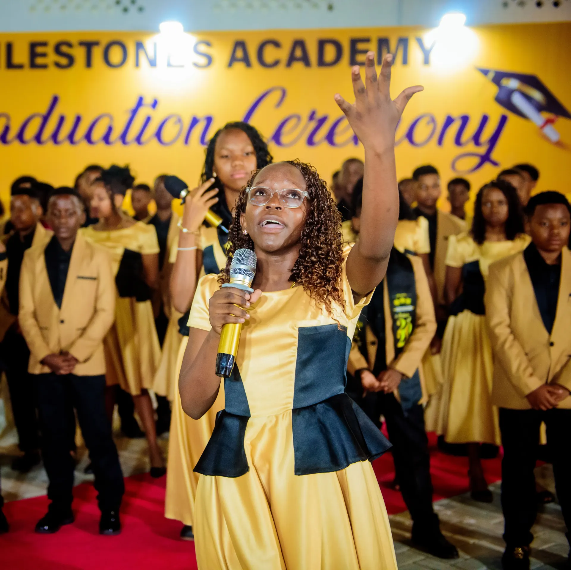A student leading a graduation performance.