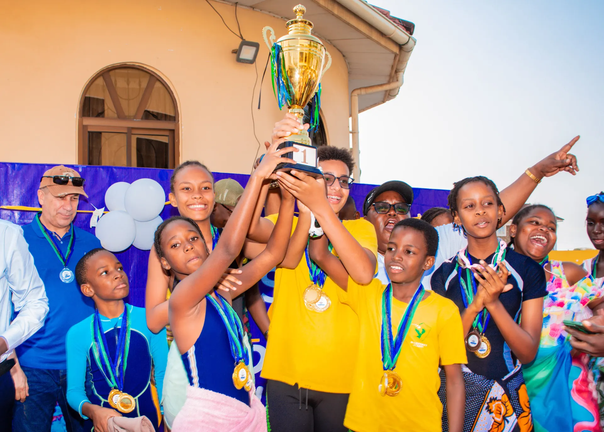 Swimming champions celebrate their trophy.
